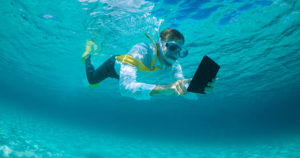 Someone snorkeling while working on a tablet