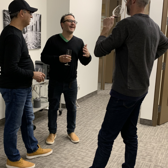 Three Ext. employees chatting and enjoying drinks in a casual office setting.