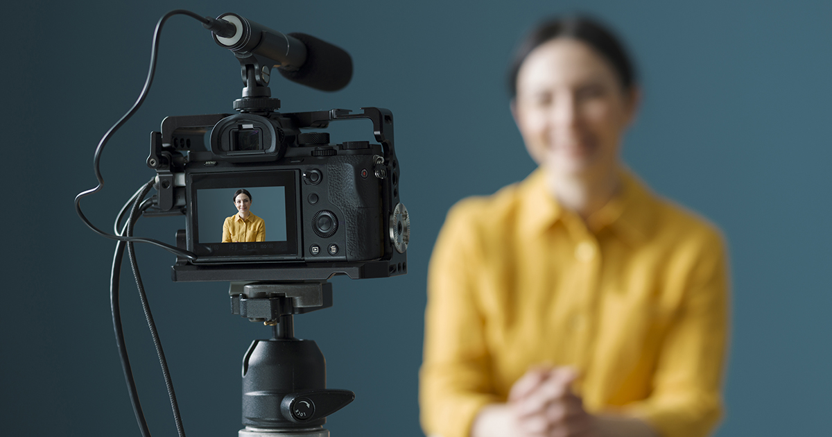 Camera capturing a person speaking during a video shoot.