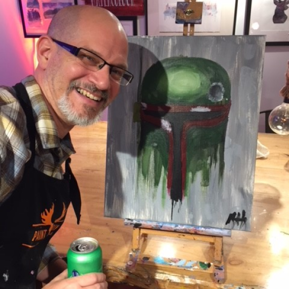 Richard Heft smiling smiling next to a painting on a canvas.