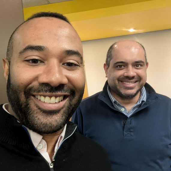 Two colleagues smiling for a selfie in the office.