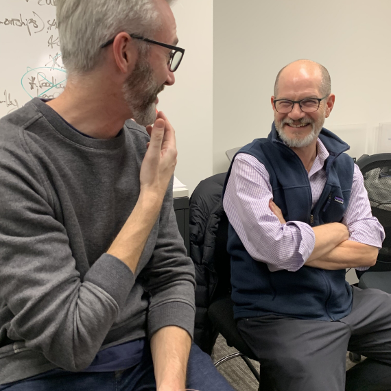 Ext. members in a candid discussion, smiling during a team meeting.